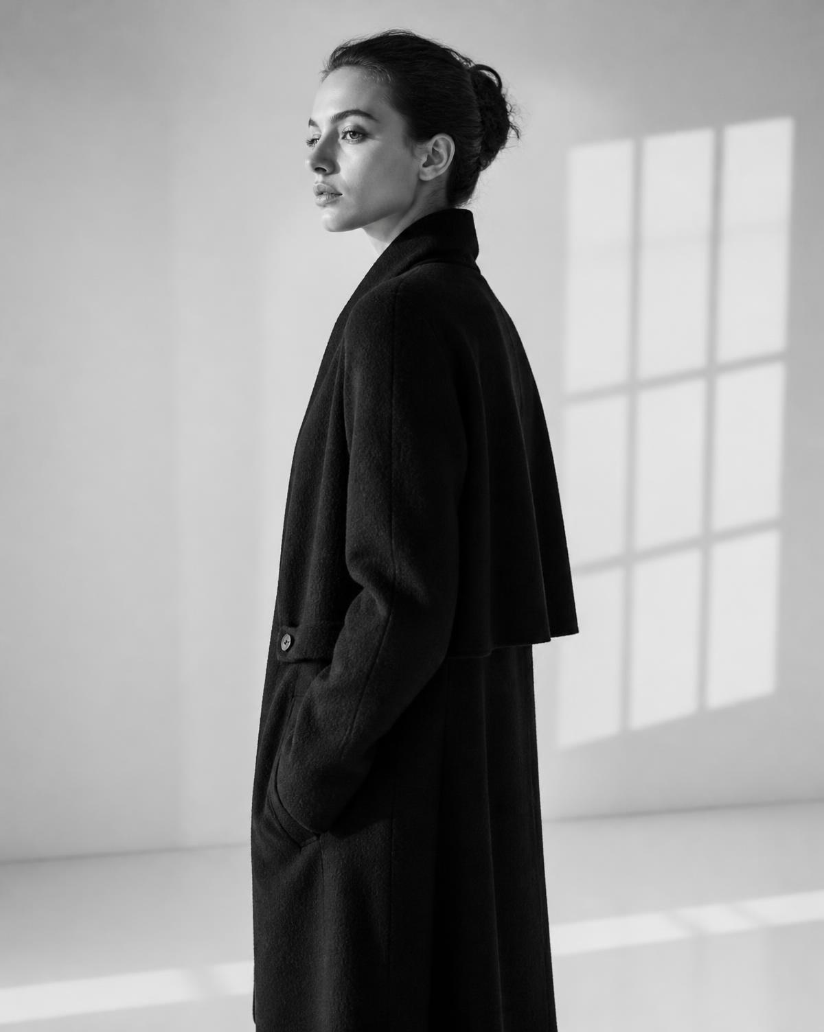 Studio portrait of a model in simple black clothing against a white backdrop